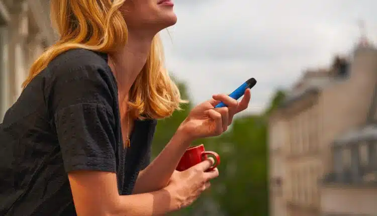 a woman holding a cup and a cell phone